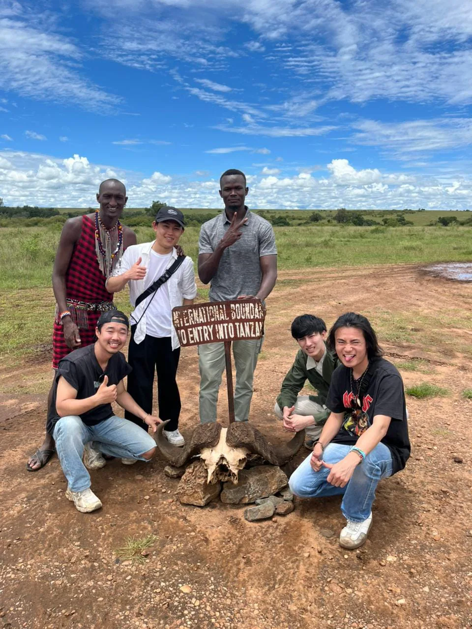 Guests and local guides gathered at a conservancy boundary marker